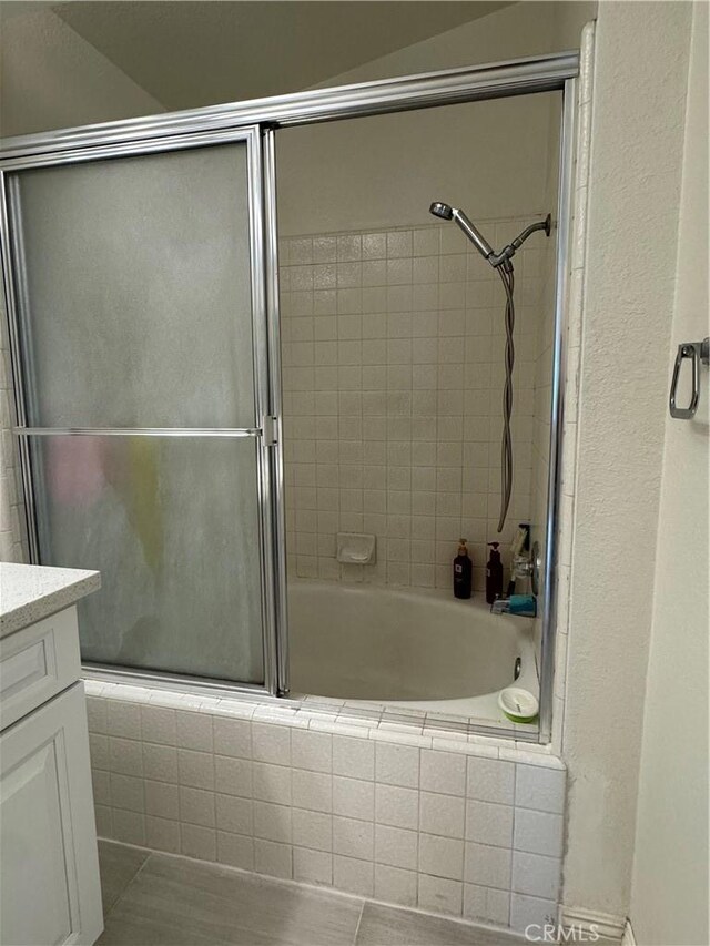 bathroom featuring tiled shower / bath combo and vanity