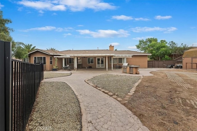1232 Tucson Ave, Norco, CA 92860 - back of property featuring fence, a patio area, stucco siding, and a chimney
