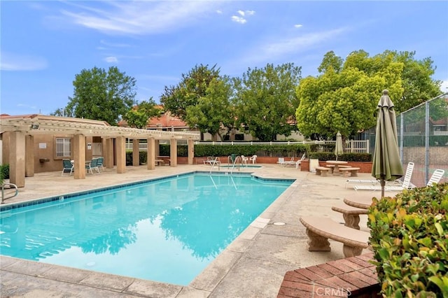 community pool featuring fence and a patio
