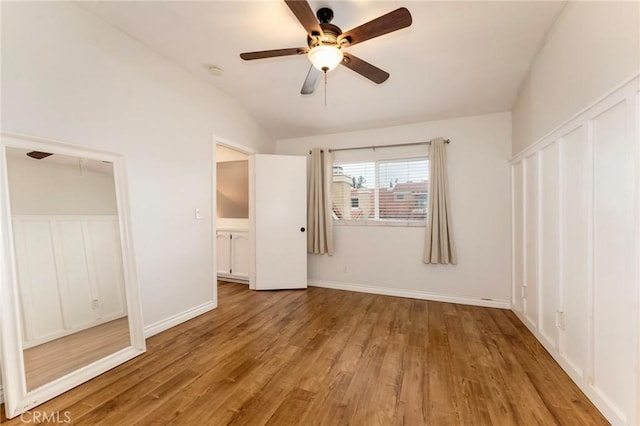 unfurnished bedroom featuring lofted ceiling, wood finished floors, ceiling fan, and baseboards