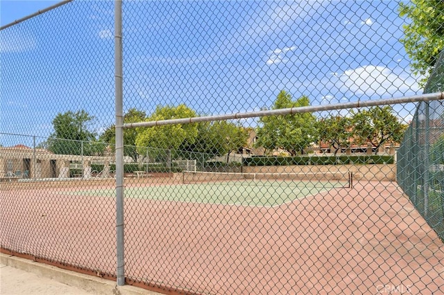 view of tennis court featuring fence