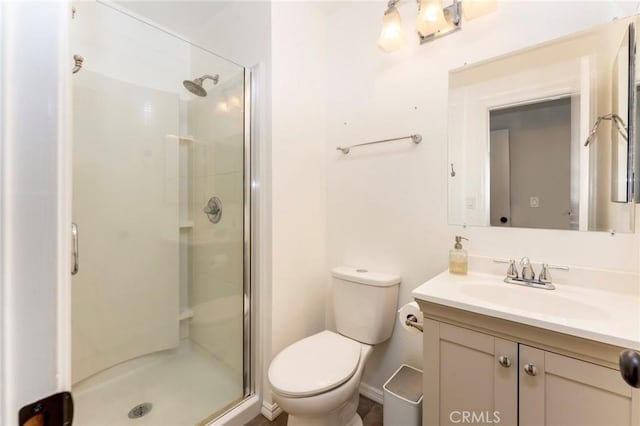 full bathroom with a stall shower, toilet, and vanity