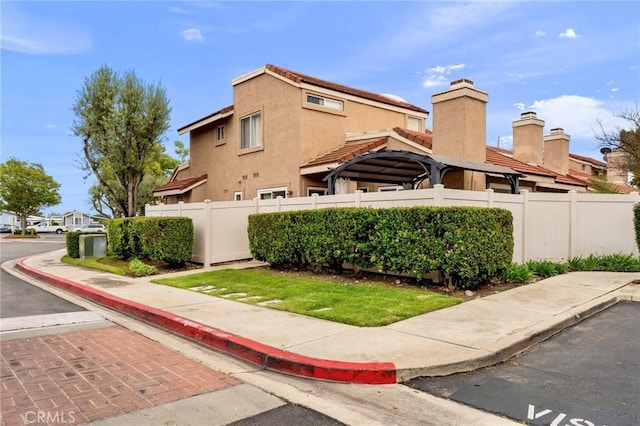 exterior space featuring fence, stucco siding, and a chimney