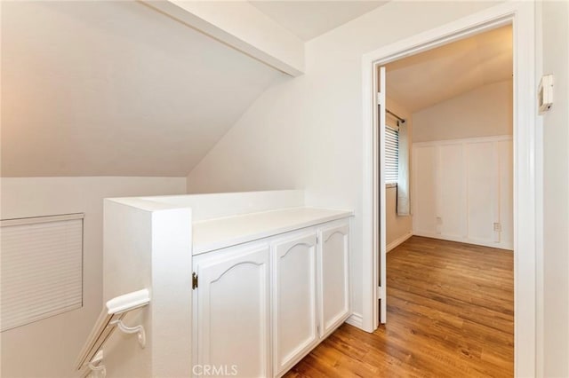 hall featuring lofted ceiling and light wood-style flooring