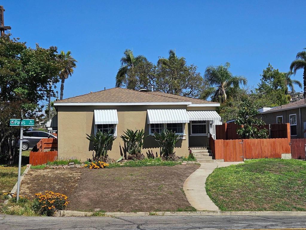 bungalow-style home featuring stucco siding, fence, entry steps, and a shingled roof