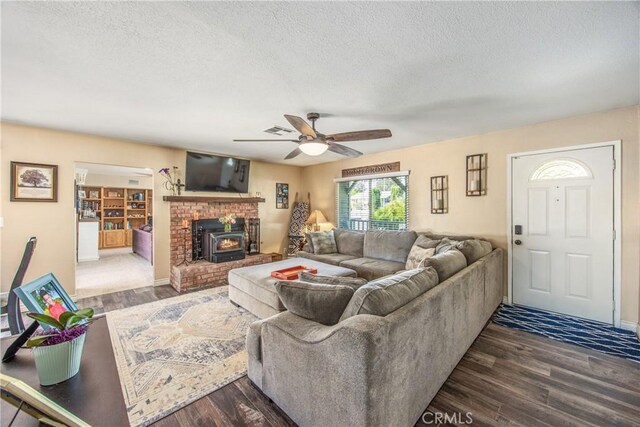 living area with a textured ceiling, ceiling fan, and wood finished floors