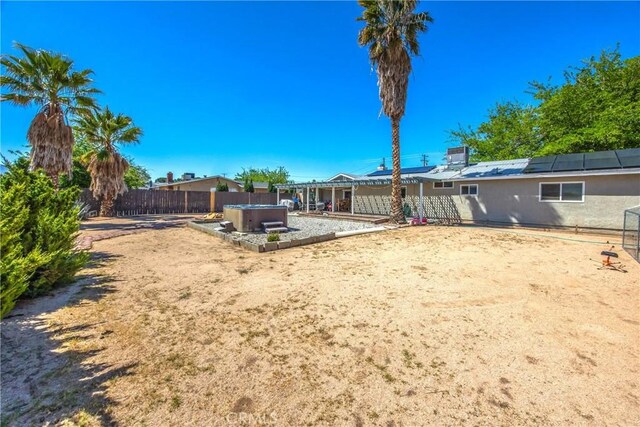 fenced backyard featuring a hot tub