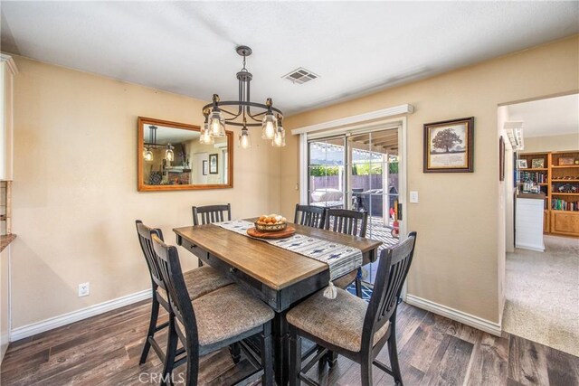 dining space with wood finished floors, baseboards, and a chandelier