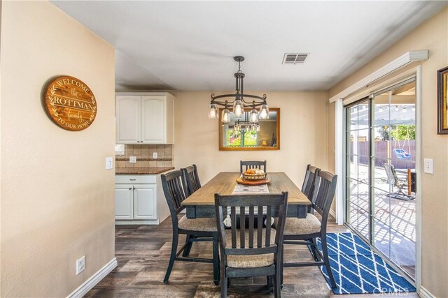 dining space with a chandelier and dark wood-style flooring