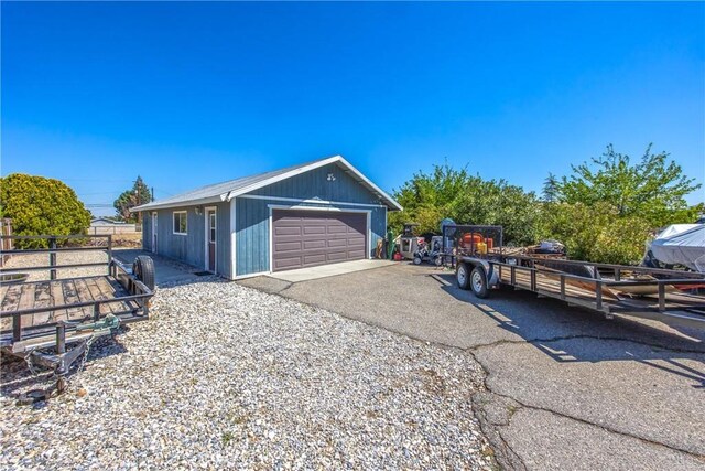 view of home's exterior with a garage, fence, and an outdoor structure