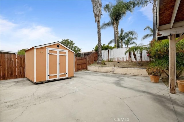 view of patio / terrace featuring a shed, an outbuilding, and a fenced backyard