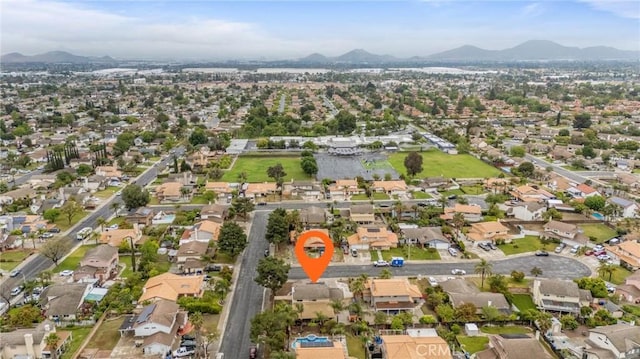 aerial view of property and surrounding area featuring mountains and nearby suburban area