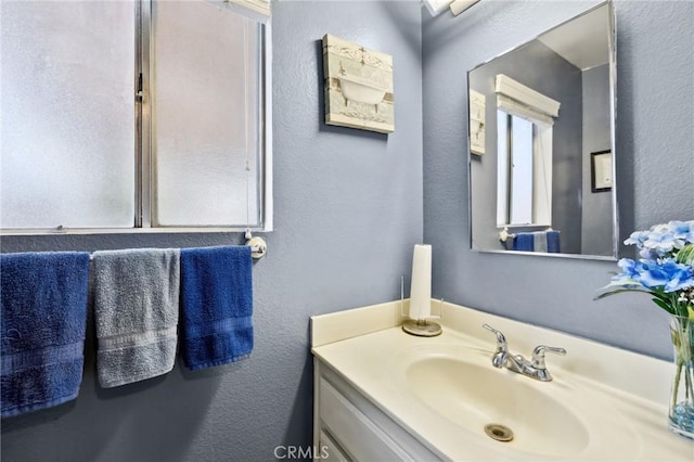 bathroom featuring a textured wall and vanity