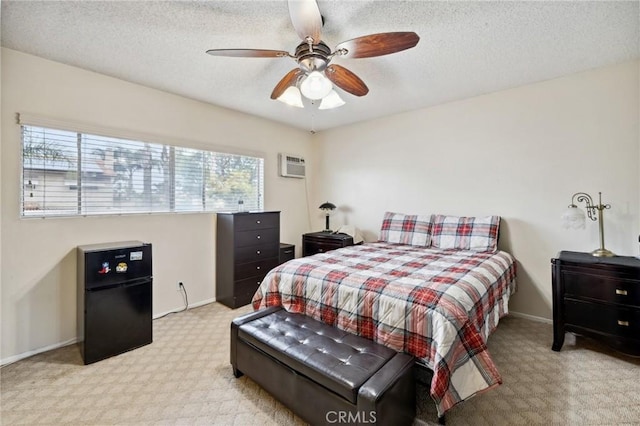 bedroom featuring carpet flooring, a wall mounted AC, baseboards, ceiling fan, and a textured ceiling