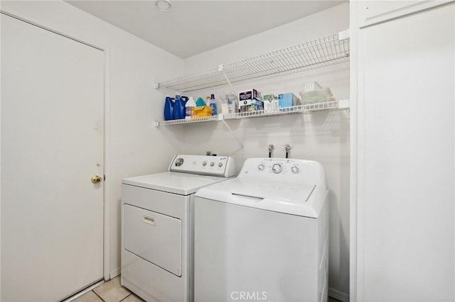 washroom with separate washer and dryer and light tile patterned flooring