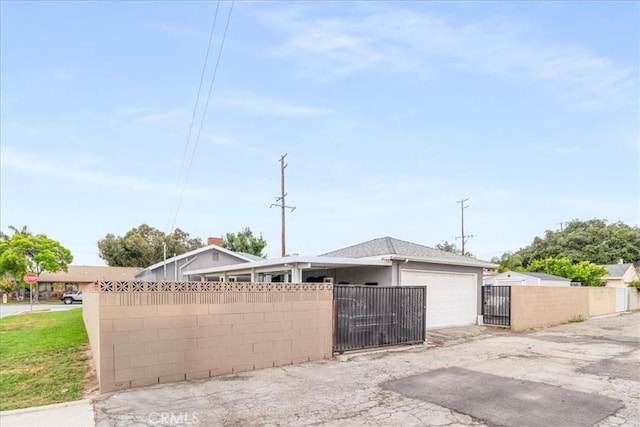 view of side of home with a fenced front yard and a gate