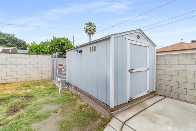 view of shed with a fenced backyard and a gate