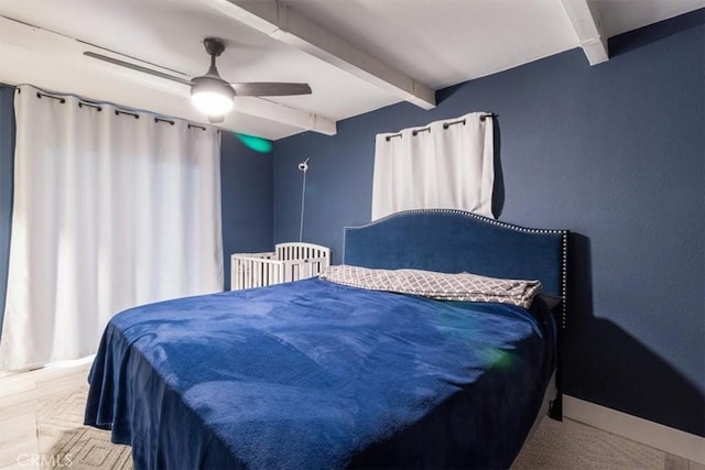 bedroom with beamed ceiling and a ceiling fan