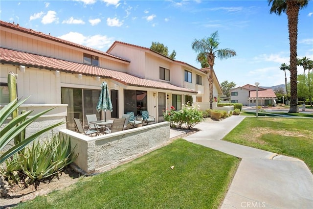 6134 Arroyo Rd Unit 3, Palm Springs, CA 92264 - back of house featuring a tile roof, a lawn, and a patio area