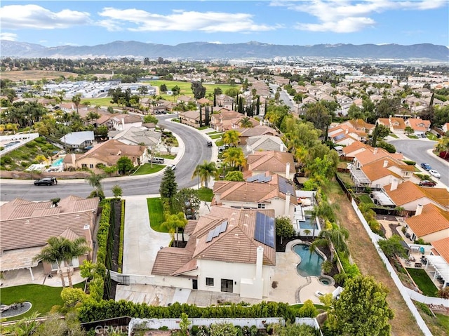 aerial perspective of suburban area featuring a mountainous background and a pool area