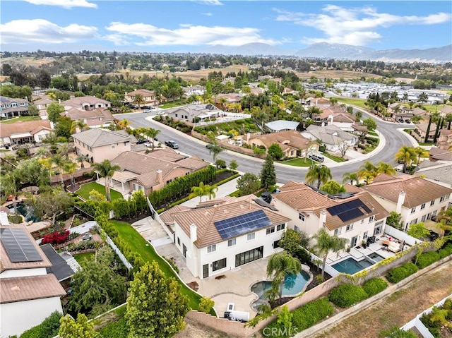 aerial perspective of suburban area with a mountain backdrop and a pool area