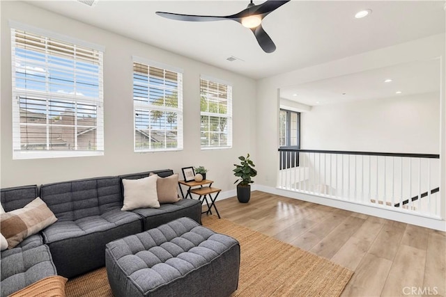 living room featuring wood finished floors, a ceiling fan, recessed lighting, and baseboards