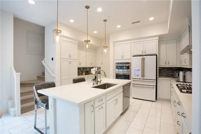 148 Spectacle, Irvine, CA 92618 - kitchen featuring appliances with stainless steel finishes, tasteful backsplash, light countertops, recessed lighting, and hanging light fixtures