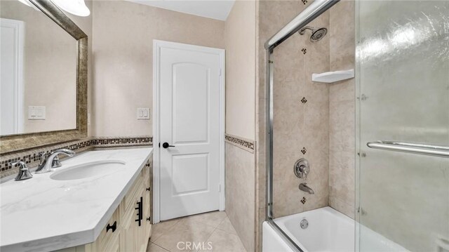 full bath featuring combined bath / shower with glass door, tile patterned floors, and vanity