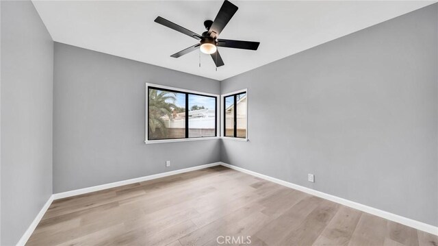 spare room with light wood-type flooring and baseboards