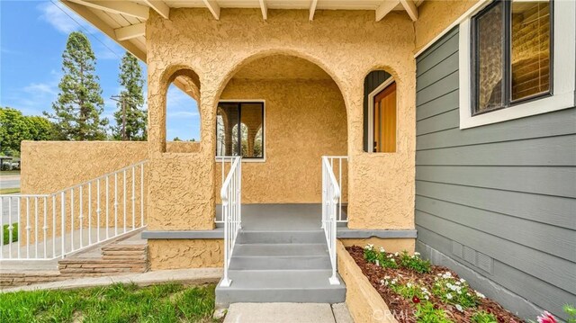 doorway to property featuring stucco siding