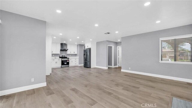 unfurnished living room featuring baseboards, recessed lighting, and light wood-type flooring