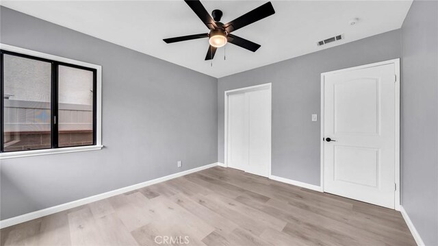 unfurnished bedroom with wood finished floors, baseboards, a closet, and ceiling fan
