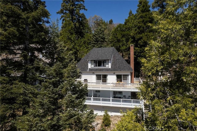28956 Palisades Dr, Lake Arrowhead, CA 92352 - rear view of property with a chimney, a balcony, and a wooded view