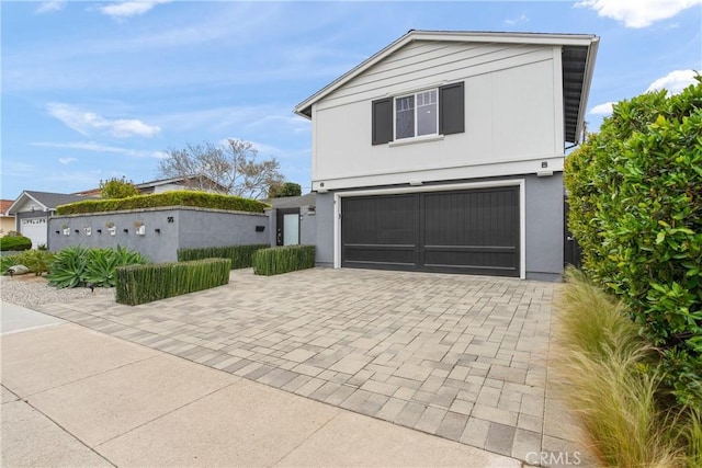 515 Traverse Dr, Costa Mesa, CA 92626 - view of front facade featuring decorative driveway, stucco siding, and a garage