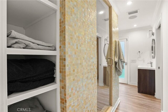 515 Traverse Dr, Costa Mesa, CA 92626 - bathroom featuring crown molding, wood finished floors, vanity, and a stall shower