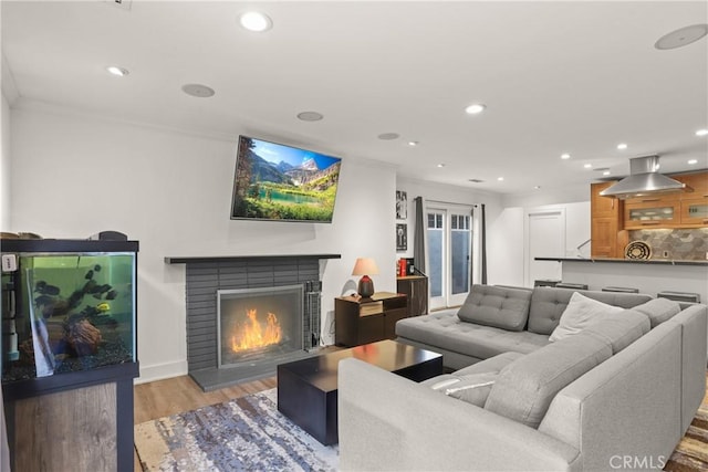 515 Traverse Dr, Costa Mesa, CA 92626 - living room with ornamental molding, light wood-style flooring, recessed lighting, a lit fireplace, and baseboards