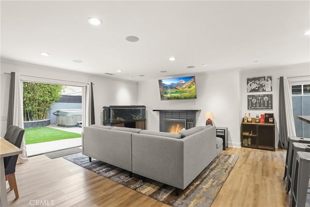 515 Traverse Dr, Costa Mesa, CA 92626 - living room with light wood finished floors, a warm lit fireplace, ornamental molding, and recessed lighting