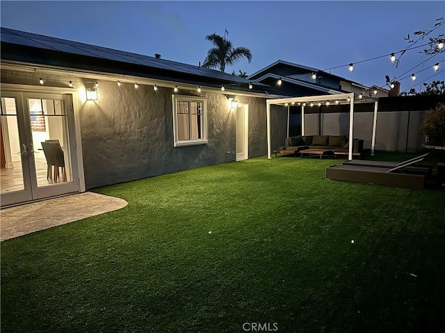 515 Traverse Dr, Costa Mesa, CA 92626 - back of house featuring an outdoor living space, roof mounted solar panels, french doors, and stucco siding