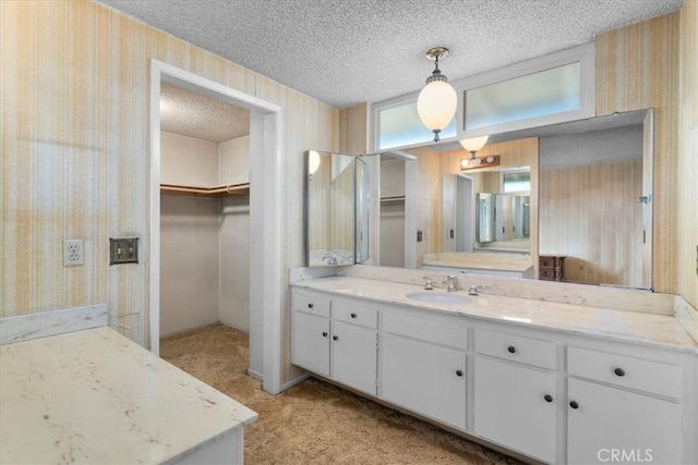 19923 Mildred Ave, Torrance, CA 90503 - full bathroom with wallpapered walls, a textured ceiling, vanity, and a spacious closet