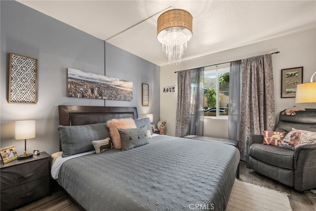 bedroom featuring wood finished floors and a chandelier