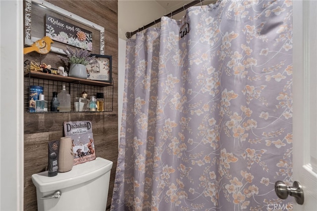 bathroom with toilet and a shower with shower curtain