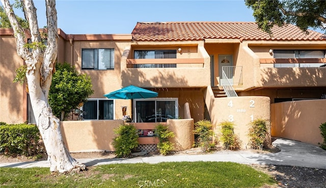 townhome / multi-family property with stucco siding and a tile roof