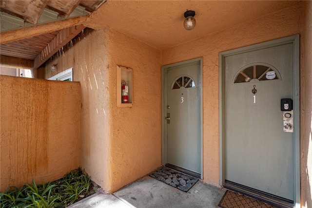 view of exterior entry with stucco siding