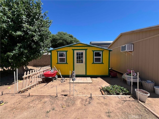 7477 Corona Ave, Hesperia, CA 92345 - rear view of property featuring fence, a wall unit AC, and an outdoor structure