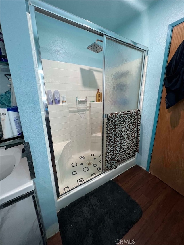 7477 Corona Ave, Hesperia, CA 92345 - full bath featuring wood finished floors, a textured wall, and a shower stall