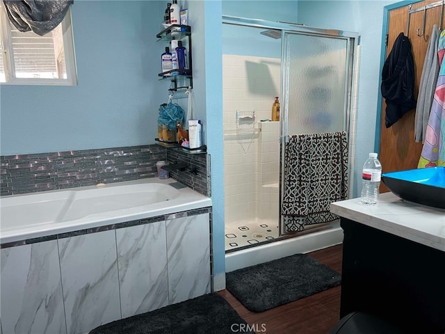 7477 Corona Ave, Hesperia, CA 92345 - bathroom with a shower stall, wood finished floors, a bath, and vanity