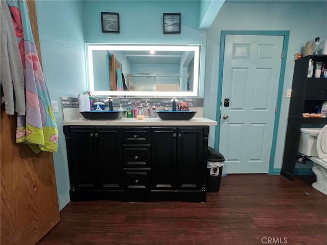 7477 Corona Ave, Hesperia, CA 92345 - bathroom featuring decorative backsplash, double vanity, and wood finished floors