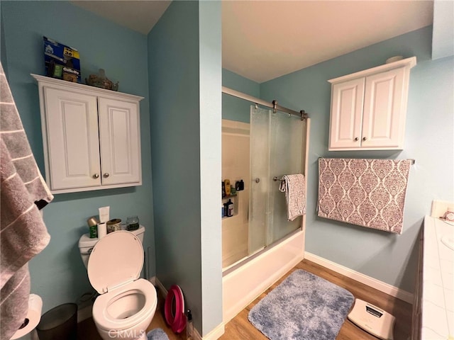 7477 Corona Ave, Hesperia, CA 92345 - bathroom with wood finished floors, bath / shower combo with glass door, toilet, and baseboards