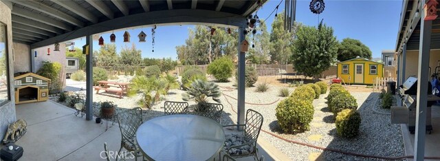 7477 Corona Ave, Hesperia, CA 92345 - view of patio with a storage unit, an outbuilding, fence, and outdoor dining space