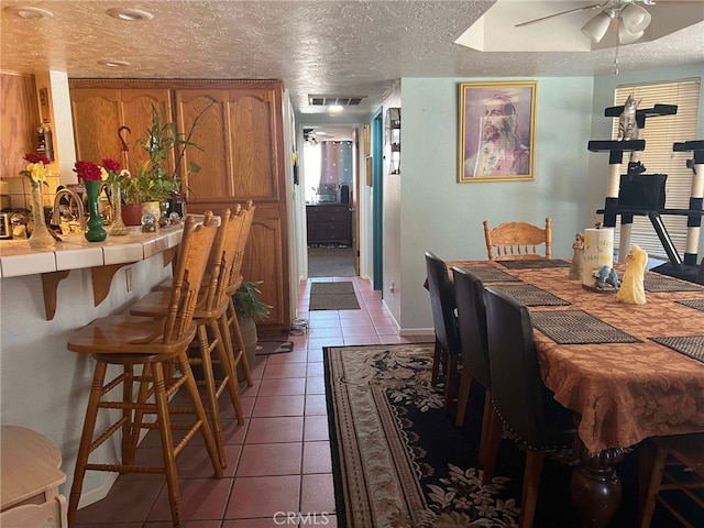 7477 Corona Ave, Hesperia, CA 92345 - dining space with light tile patterned floors, a ceiling fan, and a textured ceiling